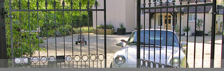 gates opening to a front yard where a car is waiting to leave the premises