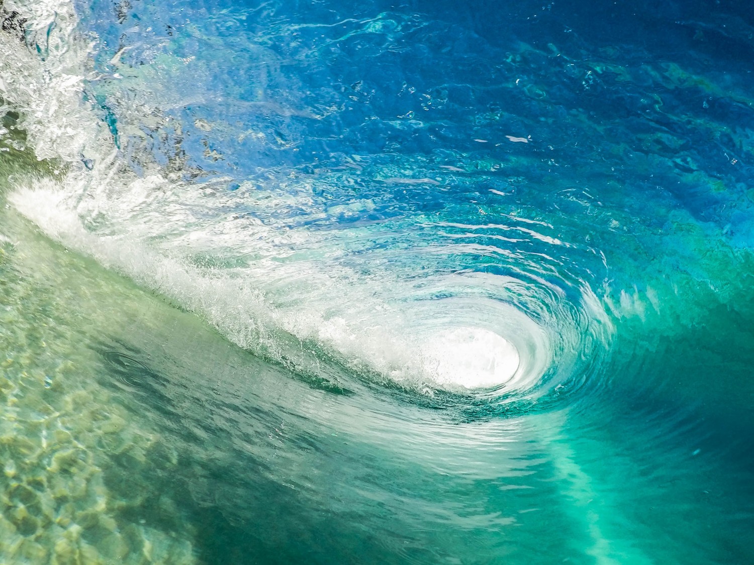 a picture taken inside a wave rolling to form a tunnel of water