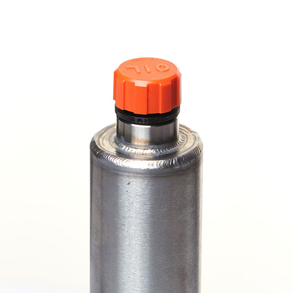 a close up of a filler cap and port on top of a hydraulic reservoir